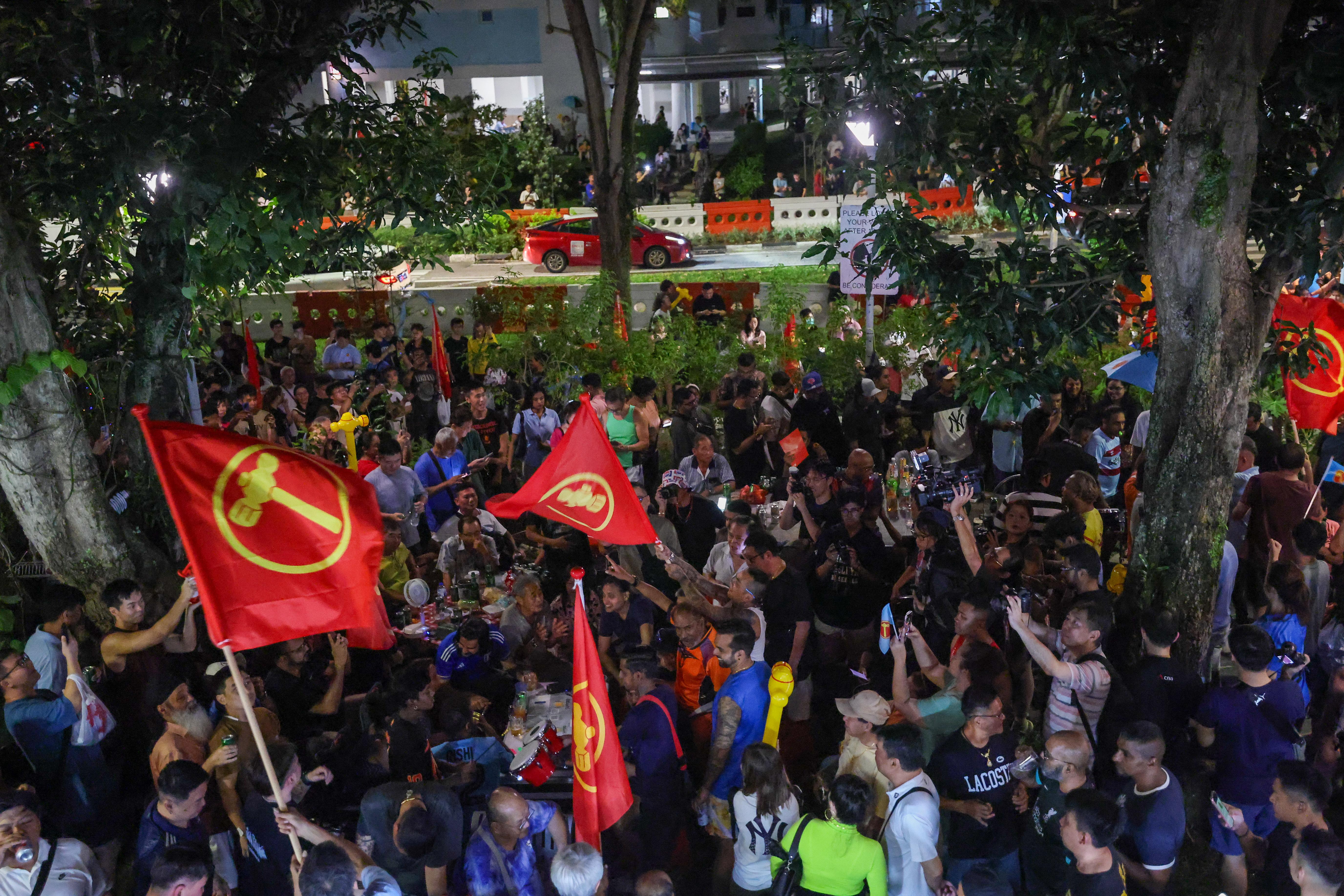 工人党支持者5月3日在全国大选开票当晚,聚集在后港5道第322座组屋的“燕飞来”咖啡店周围,等候开票结果。(白艳琳摄)