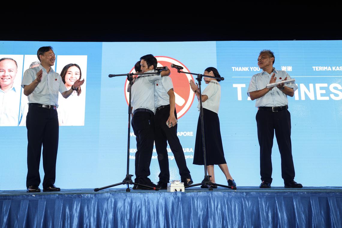 工人党参选淡滨尼集选区的王锐斌(左起)、莫哈默费沙、唐光伟、蒋佩姗和陈钦德感谢选民支持。唐光伟感谢领军的莫哈默费沙过去15年来在阿裕尼集选区作出的贡献,并拥抱他。(关俊威摄)