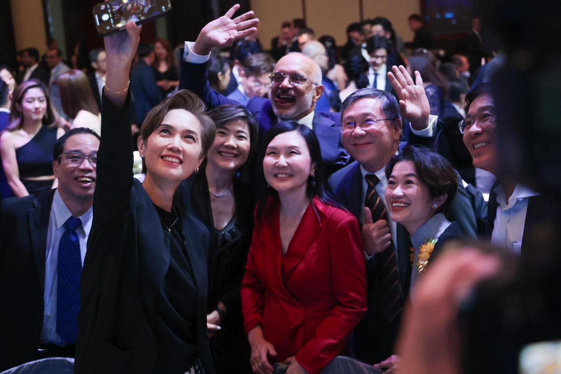 数码发展及新闻部长杨莉明(前排左)和新加坡电脑学会会长林镁绢(中,红衣者)等人在晚宴上合照。(张俊杰摄)