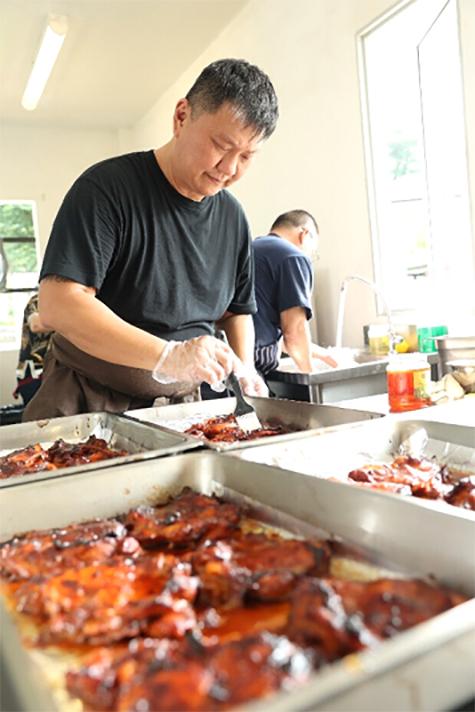 突破村庄主厨陈明裕(前)教导学员烹煮红烧鸡肉。他将与突破樟宜村法国餐馆主厨张德同共同负责培训任务,并参与中央厨房的设计和设备采购。(突破宣道之家提供)