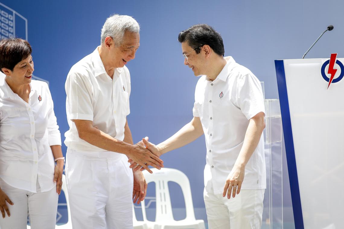 主政20年的国务资政李显龙(中),去年把总理职务交给黄循财总理(右),我国政治领导班子正式交替。图为人民行动党今年4月在大华银行大厦前广场举行的浮尔顿午间群众大会,出席者包括总理公署部长兼财政部及国家发展部第二部长英兰妮(左)。(档案照片)
