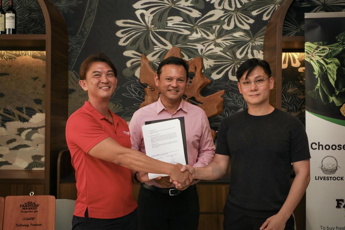 新加坡鲜农总会首席执行官张国健(左)和食品批发商Merchant Brothers执行董事傅元瑞(右)签署谅解备忘录,合力支持本土生产。国防部兼永续发展与环境部高级政务部长扎吉哈(中)见证签署仪式。(张恺恩摄)