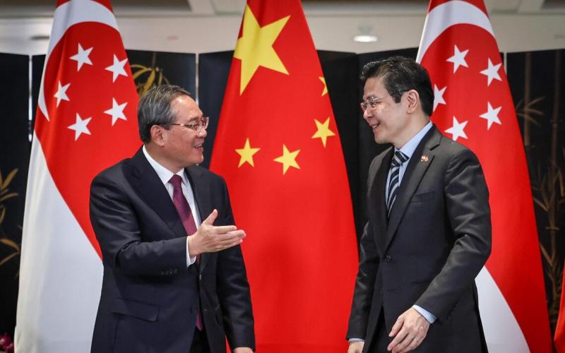 我国总理黄循财（右）和中国总理李强（左）星期六（10月25日）在国会大厦会面，并共同见证新中交换八份谅解备忘录，两人在仪式后亲切交谈。（陈渊庄摄）