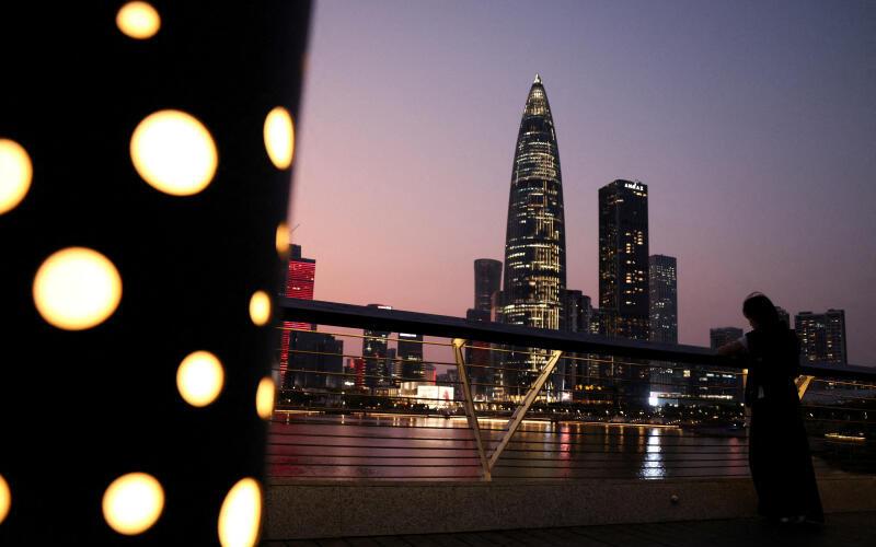 3月18日，一名行人于黄昏时分站在深圳市中心商务区附近的一座公园内。（路透社档案照）