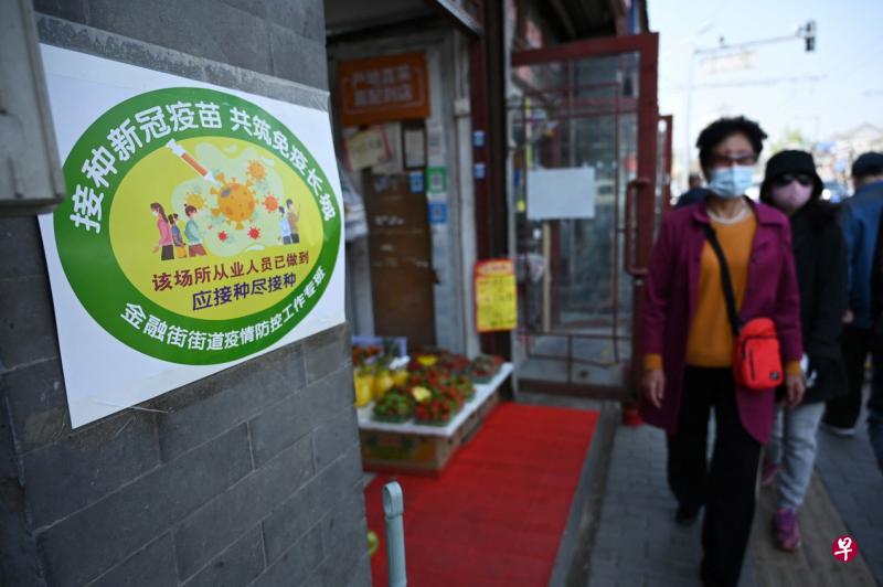 北京西城区这家水果店外张贴了黄色标识，显示该店已经有60％的员工接种了冠病疫苗。（中新社）
