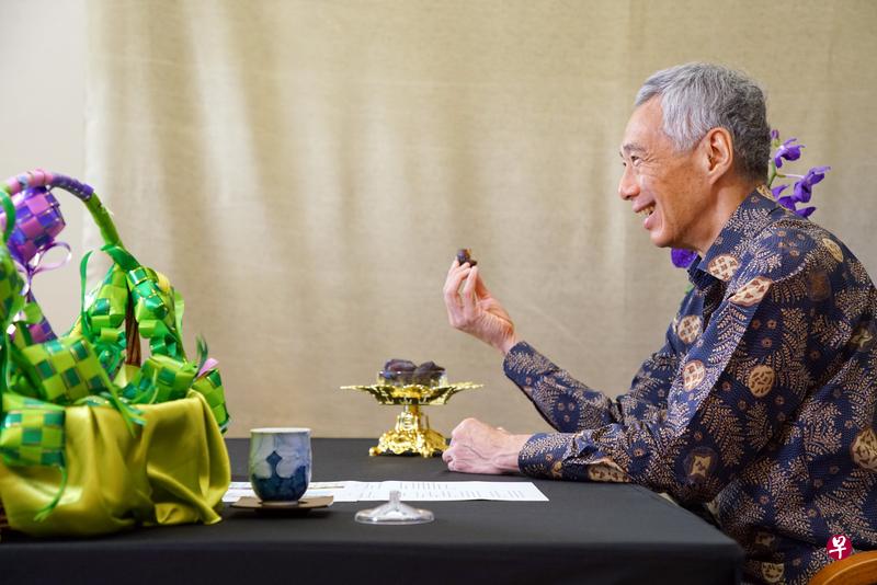 李显龙总理昨天以视讯方式与110名宗教领袖和斋戒月服务大使一起“开斋”，他手里拿着的是回教徒开斋时食用的椰枣。（通讯及新闻部提供）