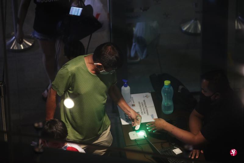 从6月15日起，更多场所将安装“SafeEntry Gateway”系统，让公众登记时更加便捷，同时检查防疫器是否还有电池。（蔡家增摄）