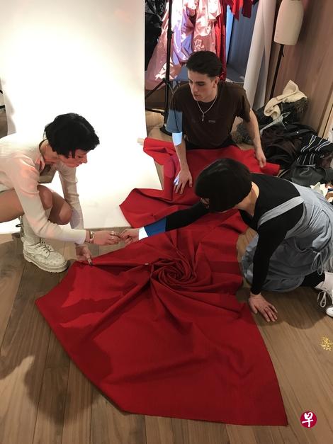 品牌在伦敦Old Bond Street专店二楼教育空间开工作坊，来自曼彻斯特艺术学院的时装专业学生正利用捐赠面料学习垂坠技巧。