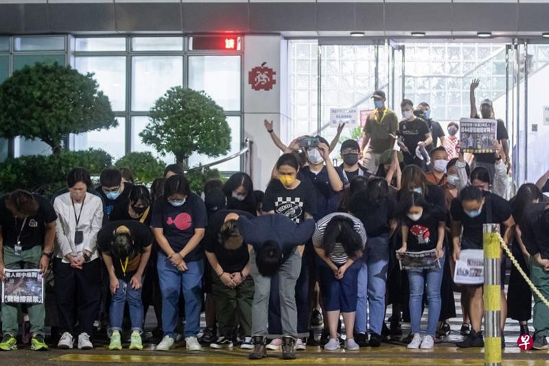 《苹果日报》工作人员昨天凌晨在最后一份报纸出版后到报社大楼外向支持者鞠躬，感谢他们多年来的支持。（彭博社）