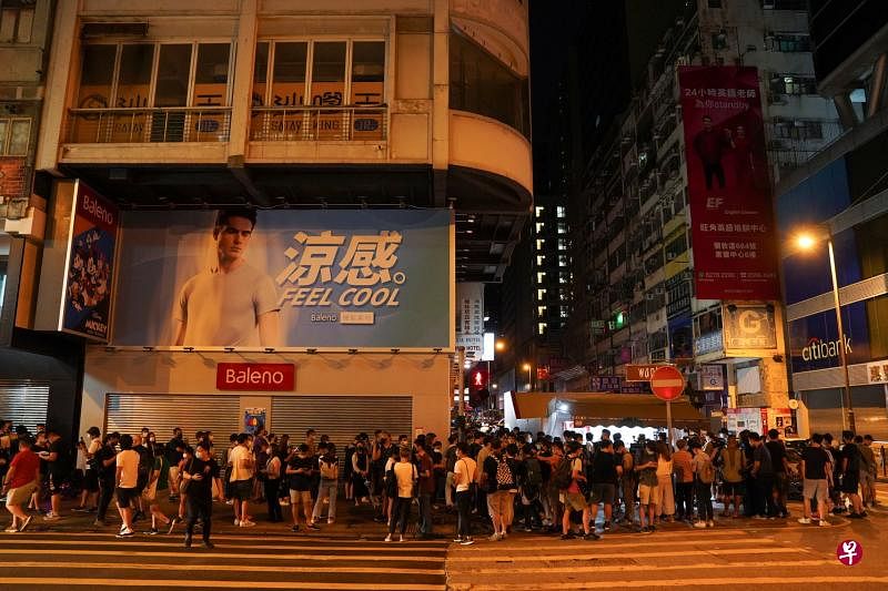 支持者昨天凌晨便到街头报摊排队购买最后一天的《苹果日报》作为纪念。（路透社）