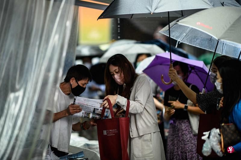 6月24日，许多香港市民冒雨排队到报摊购买最后一份《苹果日报》。（法新社）