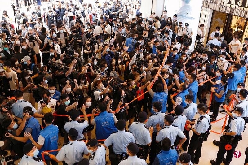 香港警方昨天尝试驱散媒体与民主支持者，防备出现群聚抗议的情况。（路透社）