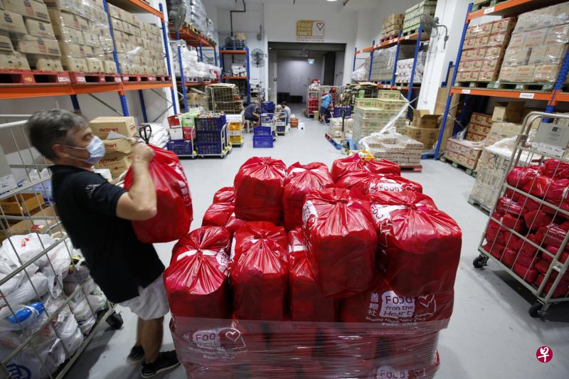 冠病疫情下，善粮社每月向弱势家庭提供的食物袋需求也有所增长。图为义工将不同物资分类打包后送到社区据点及受益人家中。（梁麒麟摄）