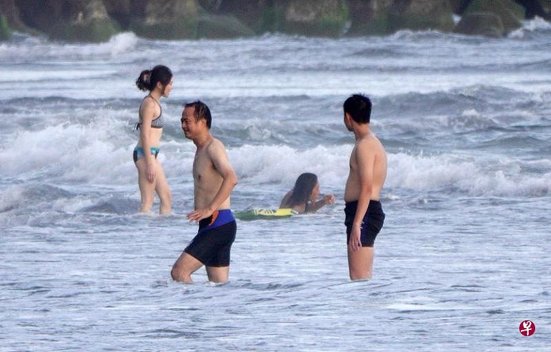 台湾仍在三级防疫警戒，不允许下海游泳、出门脱口罩，但高雄西子湾风景区周六迎来“自我解封”没戴口罩戏水的男女，有关防疫部门表示将派员到场视察。（香港中通社）