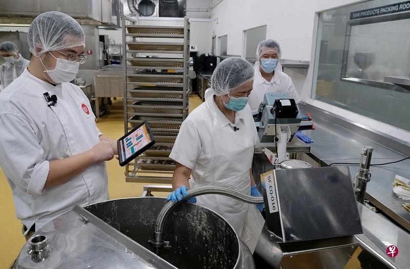 Souperfoods参与工业4.0人力资本计划后，从今年3月开始采用数码运营系统，生产经理蔡明（左一）可通过安装了该系统的平板电脑实时观察生产进度，提高工作效率。（曾坤顺摄）