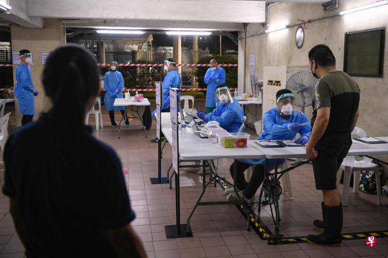 裕廊渔港加强防疫措施，图为鱼贩向工作人员登记接受冠病抗原快速检测（ART）。（海峡时报）