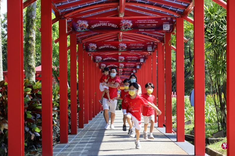 叶女士（41岁，讲师，图后排右）和丈夫蔡先生（41岁，经理）往年都会在家里和孩子与亲戚一起观看国庆庆典。由于今年庆典延期，他们昨天带着四名年幼的孩子到新加坡知新馆参与国庆日活动。一抵达现场，孩子们兴奋不已地往入口处直奔。（梁麒麟摄）