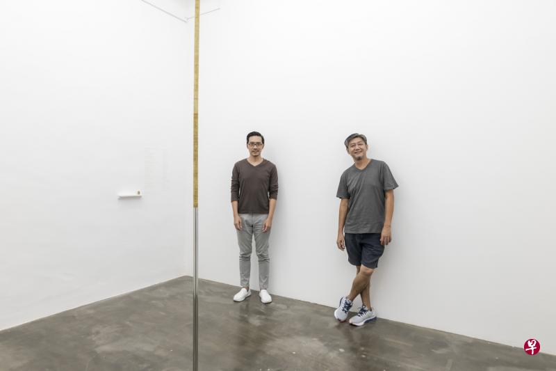 装置艺术“S$1,996/-S$831.06/-”的艺术家陈志伟（右）和策展人李鸿辉。（小图）两人向亲友筹得一元硬币，叠成“孙悟空金箍棒”装置（局部）。（主办方提供）