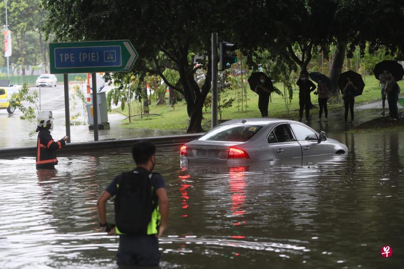 　突如其来的大雨导致淡滨尼10道和巴西立12通道交界处积水，13辆汽车受困水中。（吴伟国摄）