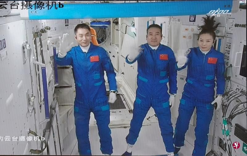 神舟十三号三名航天员翟志刚（中）、王亚平（右）、叶光富，昨天上午进驻中国空间站天和核心舱后，通过摄像连线向外界挥手致意。（新华社）
