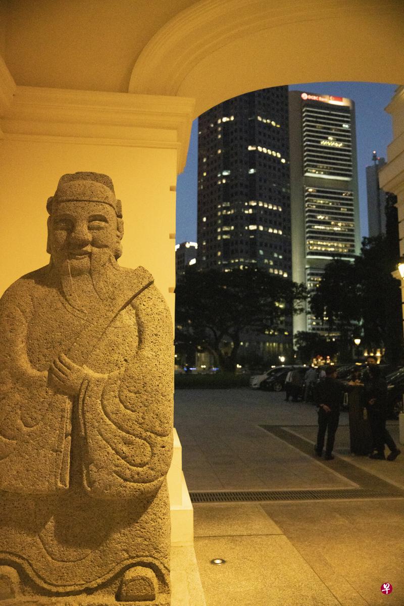 中式雕塑，对比着西式的摩天大楼，充满后现代气息。
