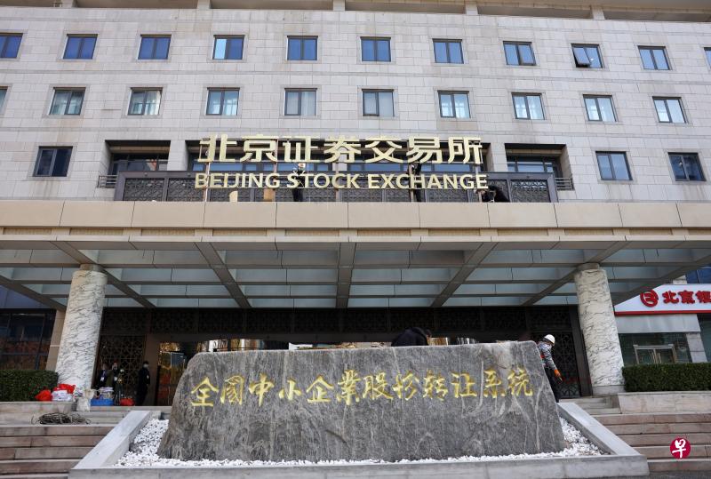 施工人员昨天在北京证券交易所办公大楼进行门牌吊装和焊接工作。 （中新社）