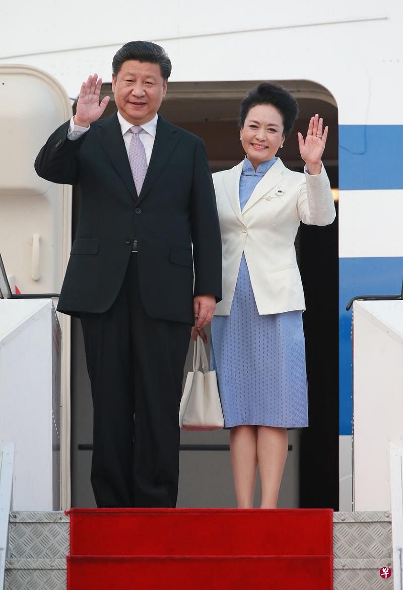 中国国家主席习近平和夫人彭丽媛2015年抵达新加坡进行国事访问，在步出舱门后向现场人群挥手致意。（档案照片）