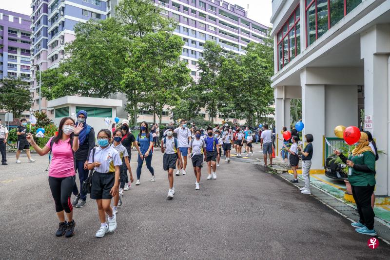 聚英小学和先驱小学昨天举行合并纪念活动，一些先驱小学师生从学校步行到聚英小学校舍，象征两校即将合并。新校徽、校服、校旗和校歌也在活动中亮相。（叶振忠摄）