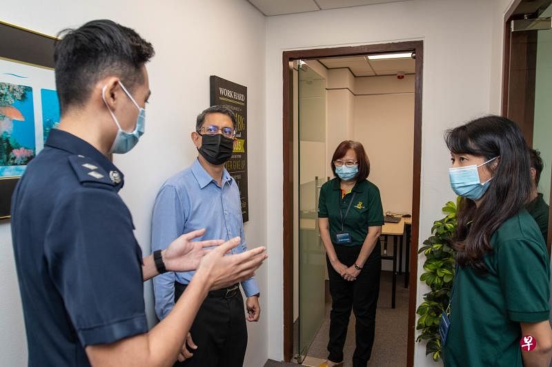 内政部兼国家发展部政务部长费绍尔副教授（左二）昨日在警察广东民大厦的HT CARES 中心与警员和义工交谈。（警方提供）