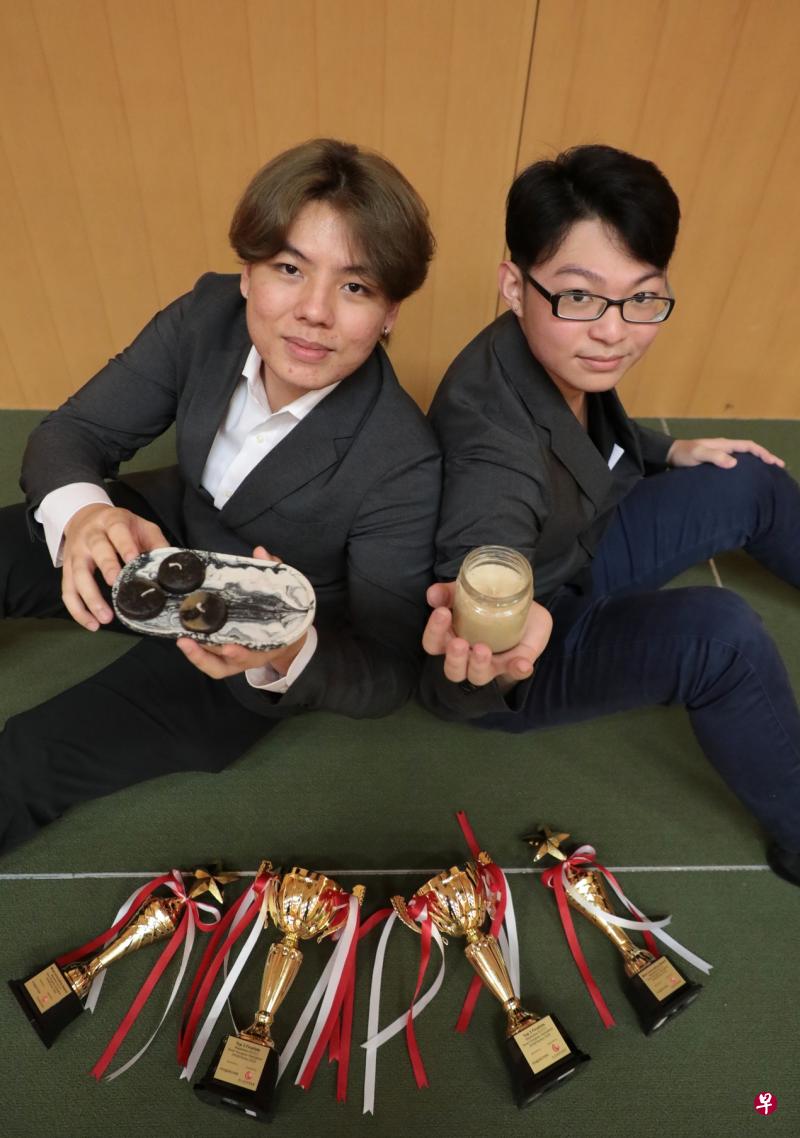 新加坡理工学院学生陈诠智（左）和张世凯，以及另外两名队友，利用咖啡渣制造出固体燃料和蜡烛，赢得今年丰树—新加坡中华总商会春到河畔编程马拉松创业竞赛的最佳创意奖及优胜奖。（林国明摄）