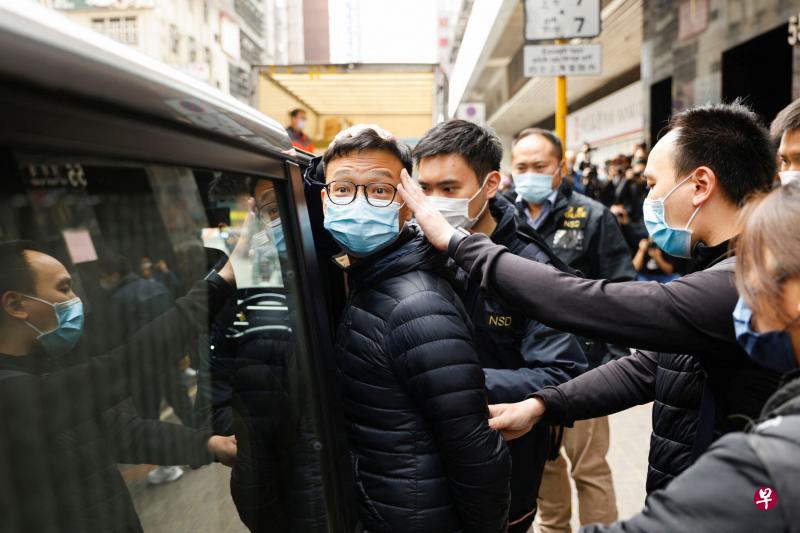 《立场新闻》的署任总编辑林绍桐（中），昨天在香港警方搜查了他的办公室后，被警员带上警车离开。（路透社）