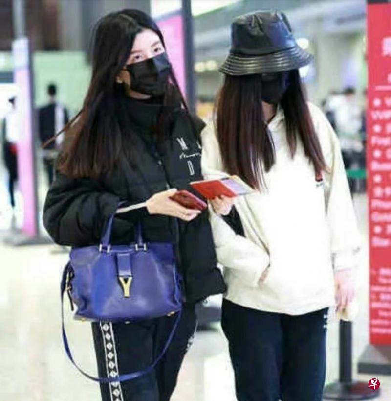 By2在上海机场现身，Yumi（右）口罩、帽子上身包紧紧。（微博图 ）