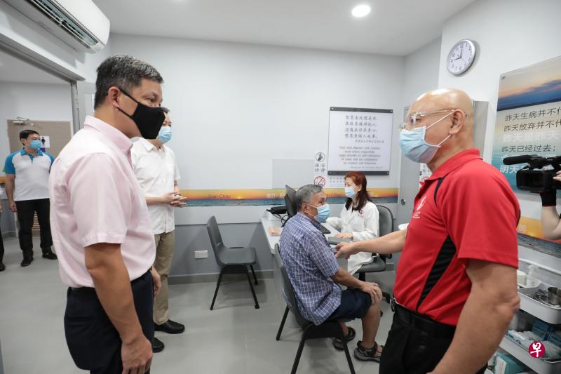 善济医社义务执行主席卓顺发（右）向教育部长陈振声（左）介绍红山分社的中医问诊服务。（林国明摄）