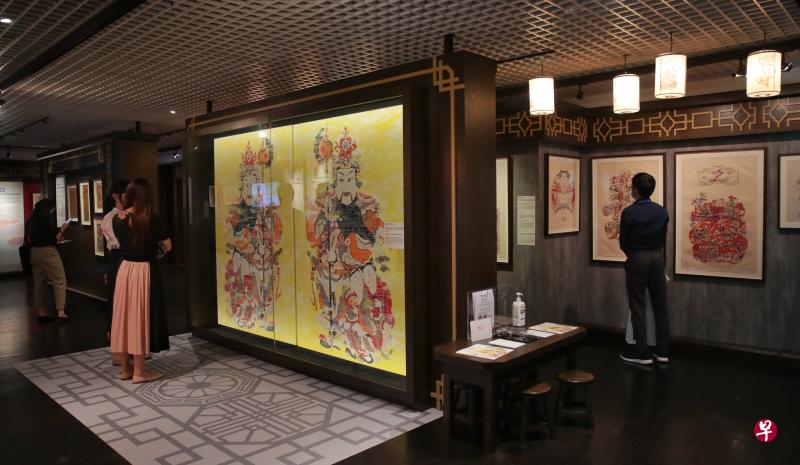 《麦当劳孩童与手机孩童》这幅年画（图中黄底画）加入了麦当劳和智能手机的现代元素，探讨东西方文化及传统与现代的融合。（海峡时报）
