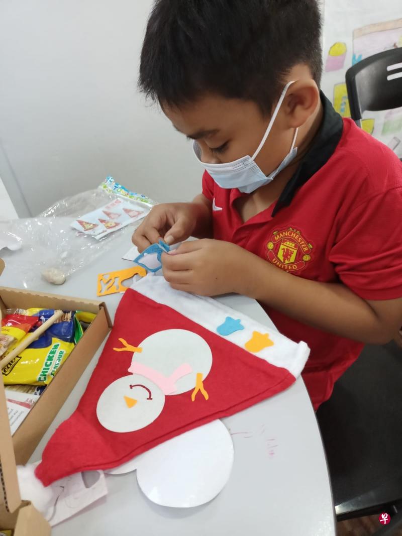 YaySanta团队为福利机构的孩子送上个人化的礼盒，义工们则通过视讯指导他们如何制作圣诞帽。（受访者提供）