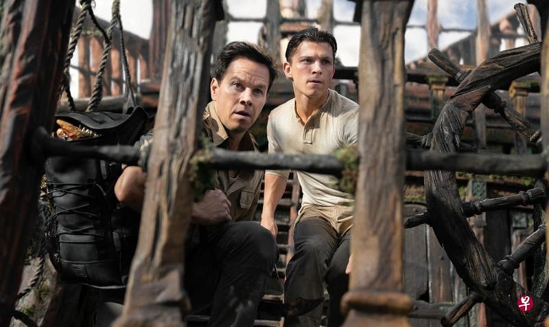 汤姆霍兰（右）与马克瓦尔贝里在《神秘海域》携手寻找宝藏时躲避敌人的子弹。（索尼电影提供）