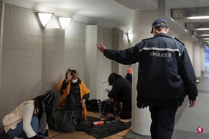 香港从昨天起严格执行两人限聚令，违者将被罚款1万港元（约1700新元）。图为一名香港警察昨天示意几名照例星期天休息、外出聚会的外籍女佣离开。（路透社）