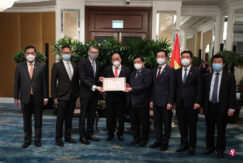 新加坡工商联合总会获得越南计划投资部的表扬证书，表扬总会在促进外国投资进入越南方面发挥重要作用。新加坡工商联合总会主席林明彦（左三）和越南国家主席阮春福（左四），连同两国代表合影。（新加坡工商联合总会提供）
