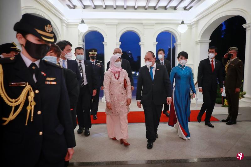 　哈莉玛总统（穿粉红长裙者）昨晚在总统府设国宴，款待来新加坡进行国事访问的越南国家主席阮春福（总统左侧）和夫人陈月秋（穿蓝裙者）。哈莉玛总统夫婿穆罕默德（总统背后）也出席了晚宴。                                                                                                   （海峡时报）