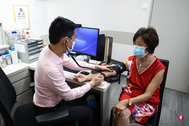 76岁的符凤英（右）过去九年每月都会定期找康威医疗集团保健护理副主管黄伟杰医生（左）看诊，省下了大笔医药费和不必要的重复检测。（李健玮摄）