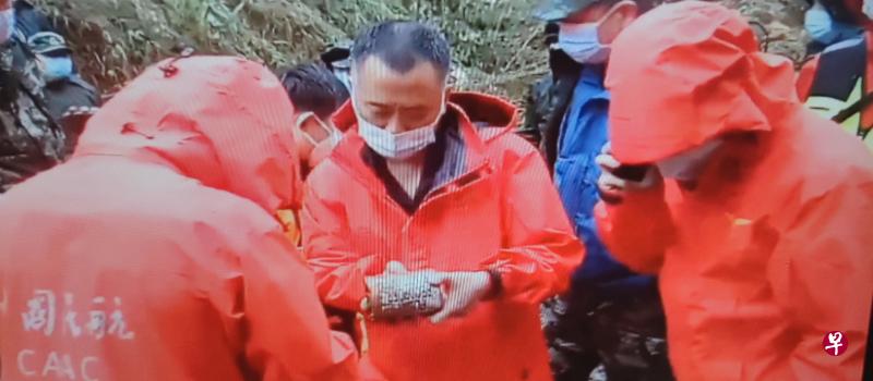 搜寻人员昨天发现失事飞机的其中一部黑箱，初步判定为驾驶舱话音记录器。（新华社）