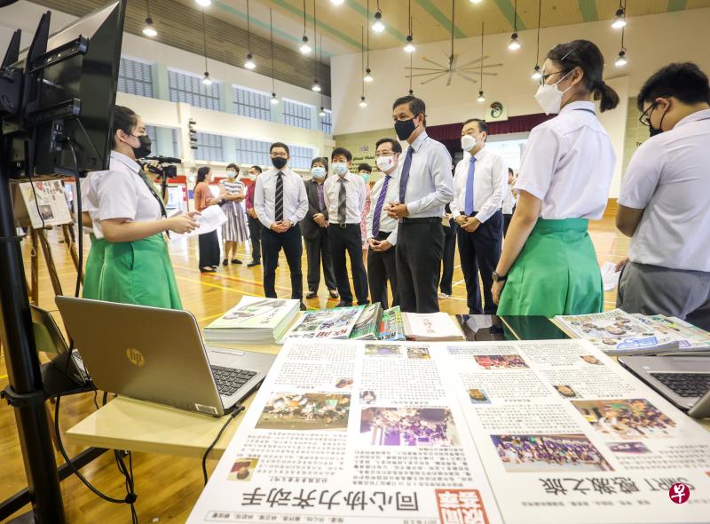 教育部长陈振声（右四）昨天到伊布拉欣中学见证签约仪式，并听学生叙述他们学习母语的过程。在场的嘉宾包括义安公司副总理兼慈善献捐小组委员会主任张绵耀（前排左起）、新报业媒体集团总裁张丽琳、新报业媒体主席许文远、义安公司总理张伟伟和义安公司副义务司理谢楚明。（叶振忠摄）