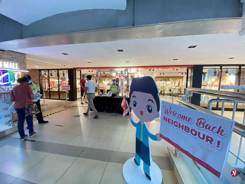 衔接新山中央车站（JB Sentral）和购物中心城中坊（City Square）的大桥，竖起“邻居，欢迎回来”的立牌。（邝启聪摄）