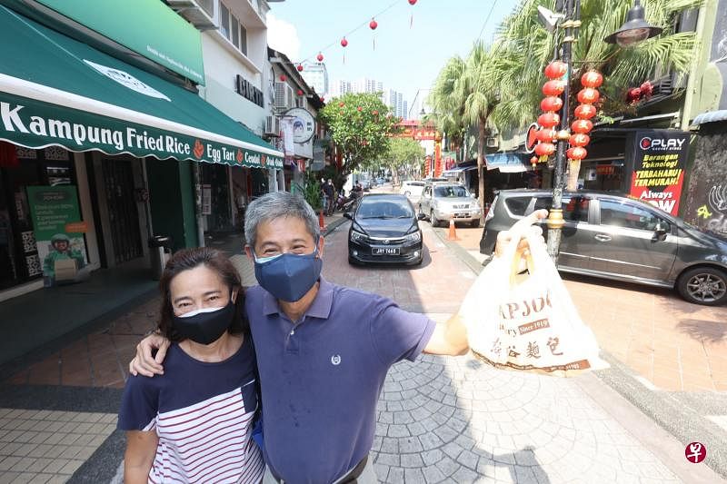 在老街开西餐馆的杨运松和太太到附近协裕面包西菓厂购买香蕉蛋糕，准备迎接在新加坡念书的女儿回家。（邝启聪摄）