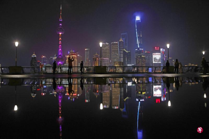 上海浦西封控筛查前夕，向来热闹的外滩滨江步道上人烟稀少，一些民众抓紧时间留影。（中新社）