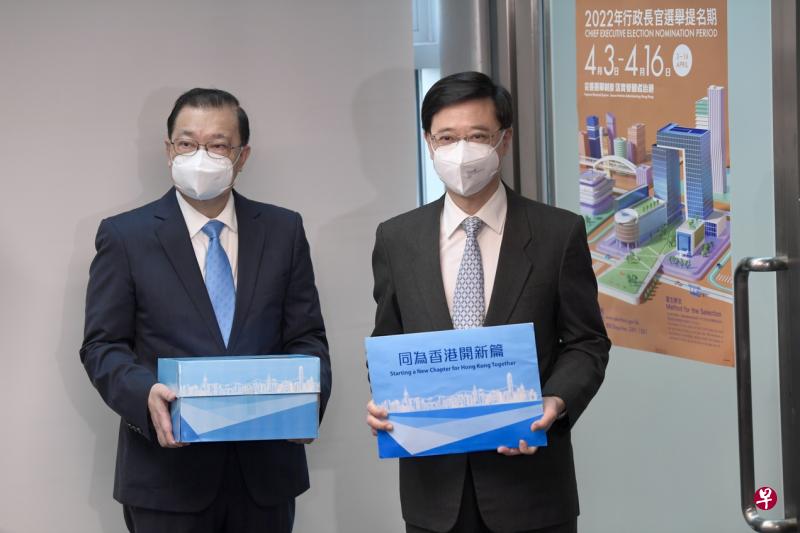 李家超（右）昨天上午到港岛中环爱丁堡广场三号展城馆，把提名表格送交选举主任，报名参选香港特区第六届行政长官选举。（中新社）