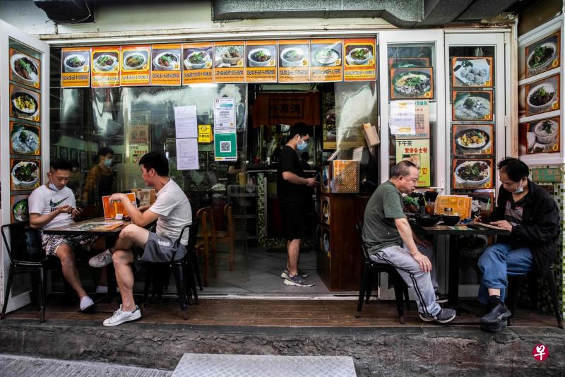 港府昨天公布，4月21日起放宽社交距离措施的细节，包括顾客人数上限放宽至四人一桌。图为香港市民昨天于食肆内用餐。（法新社）