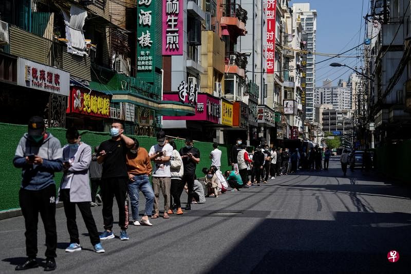 上海居民昨天在街上排队接受核酸检测。（路透社）