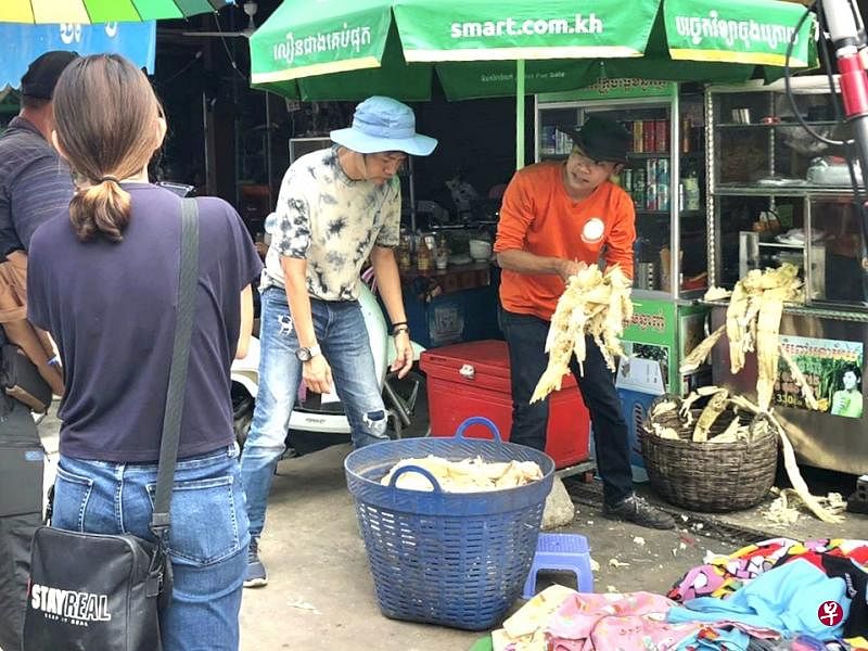  杨君伟（戴蓝帽者）跟受访者捡甘蔗渣当有机肥料。 