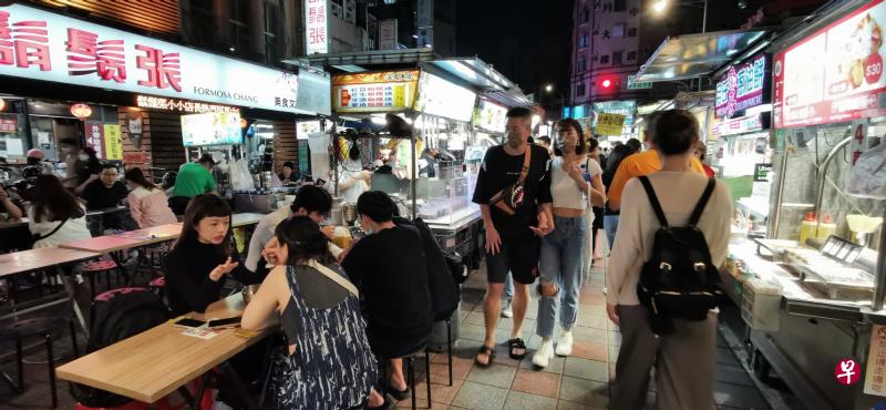 台北市的宁夏夜市今年确诊数飙升，民众却抱着平常心照旧逛市。摊贩每天营业，顾客熙来攘往。（温伟中摄）